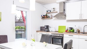 A modern kitchen with white cabinets, a built-in oven, and a coffee maker. - Seeteufel by Interhome (Norddeich)
