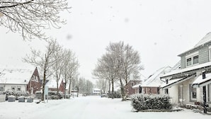 Una calle nevada con casas a ambos lados.