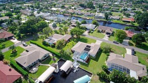 Vista aérea de una zona residencial con casas, un canal y un muelle para barcos.