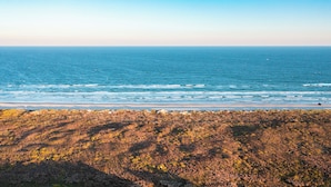 A coastal landscape with a view of the ocean and a rocky shoreline.