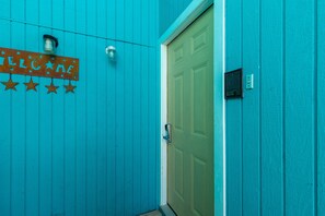 A turquoise wall with a 'WELCOME' sign and a door.
