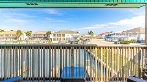 A wooden deck with a view of a marina and residential buildings.