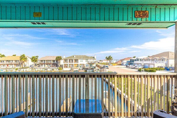 A wooden deck with a view of a marina and residential buildings.
