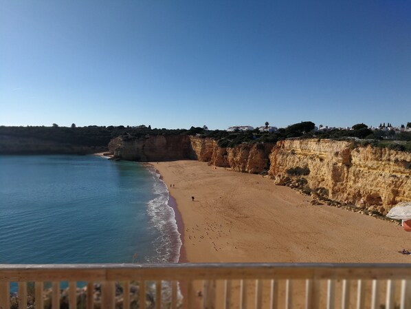 A beach with a wooden railing, clear blue water, and cliffs. - Cottage for 4 people (Silves)