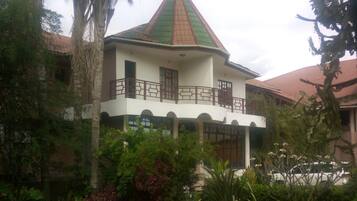 A two-story building with a green roof and a balcony.