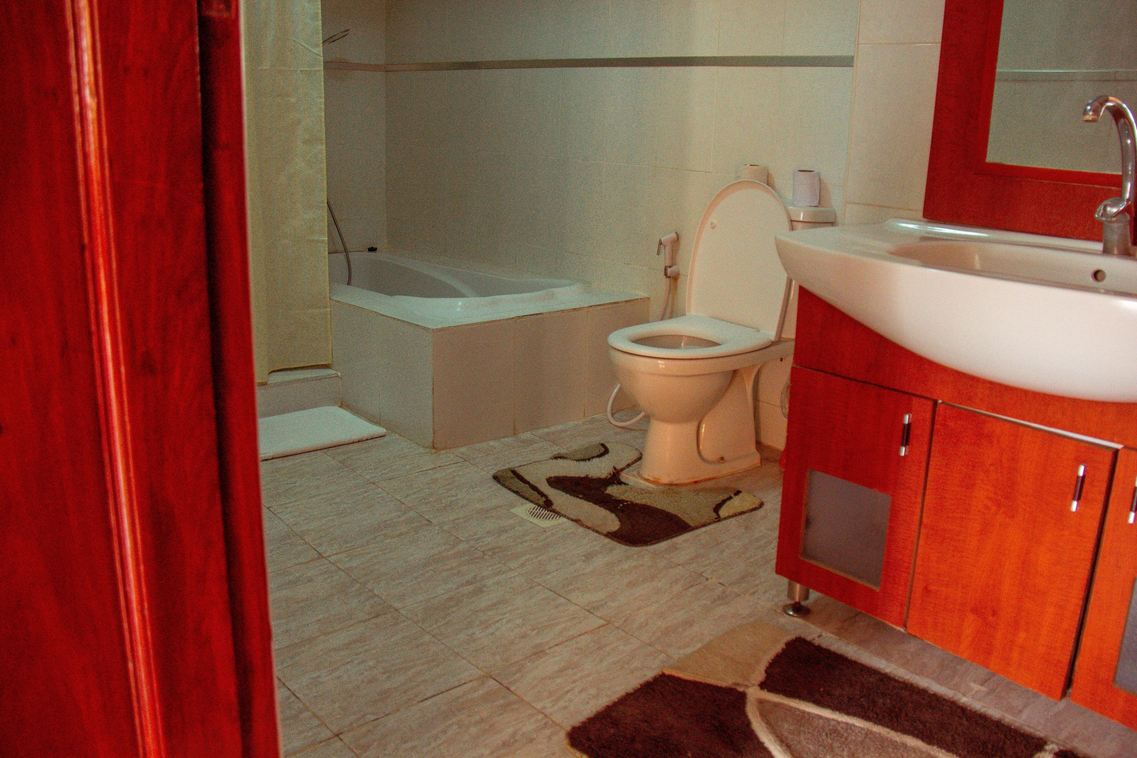A bathroom with a toilet, sink, and bathtub.
