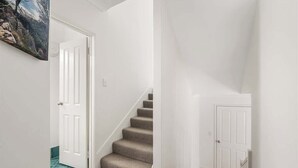 A staircase with carpeted steps leading to a white door.