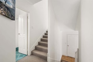 A staircase with carpeted steps leading to a white door.