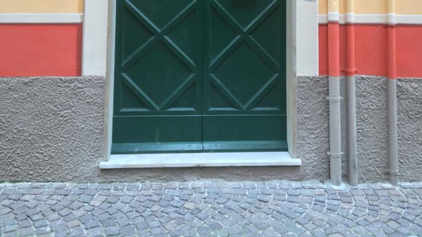 Eine grüne Doppeltür mit Griff, darüber ein Schild mit der Aufschrift 