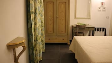 Una camera da letto con un letto, una scrivania, una sedia, un armadio e una tenda.