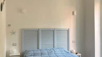 Una camera da letto con un letto, comodini e una decorazione a stella marina.