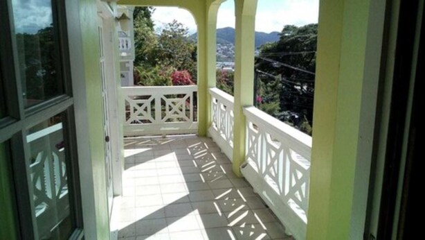 A balcony with white railings and a tiled floor, overlooking a mountainous landscape. - Tranquil Ocean Views (Gros Islet)