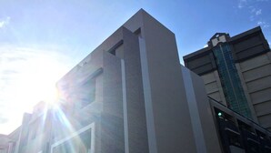A modern building with a prominent vertical design, large windows, and a visible green traffic light. - Coral Habitat (Magong)