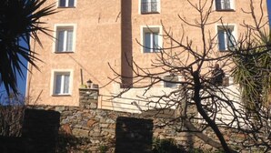 Un edificio de varios pisos con base de piedra y fachada rosa.