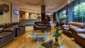 A spacious lobby with leather sofas, a glass coffee table, and a reception desk. - Hotel Beverly (Mexico City)