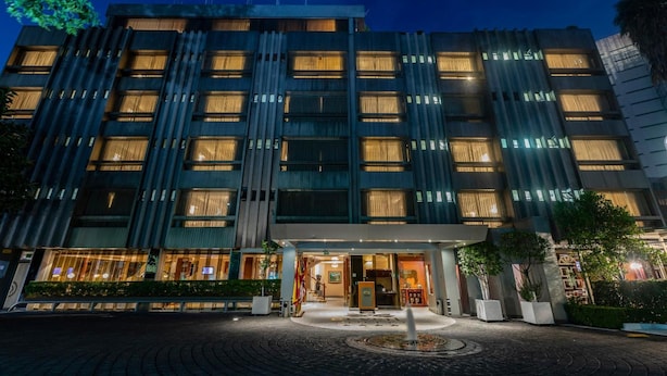 A multi-story hotel with a modern facade, large windows, and a well-lit entrance. - Hotel Beverly (Mexico City)