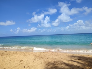 A beach with clear blue water and a sandy shore. - Villa bébélos (Pointe noire)