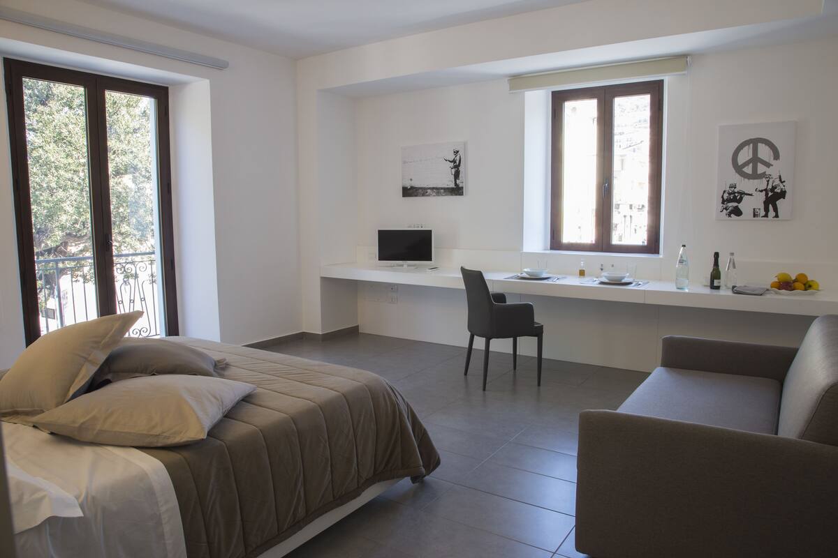 Un dormitorio con una cama, un escritorio y una silla.