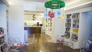 Una biblioteca con sillas transparentes, pisos de madera y estanterías.