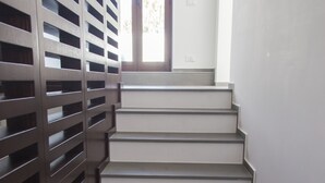 Una escalera de diseño moderno que conduce a una habitación con un amplio ventanal.