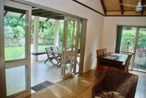 A room with a sliding glass door leading to an outdoor patio area with a table and chairs.