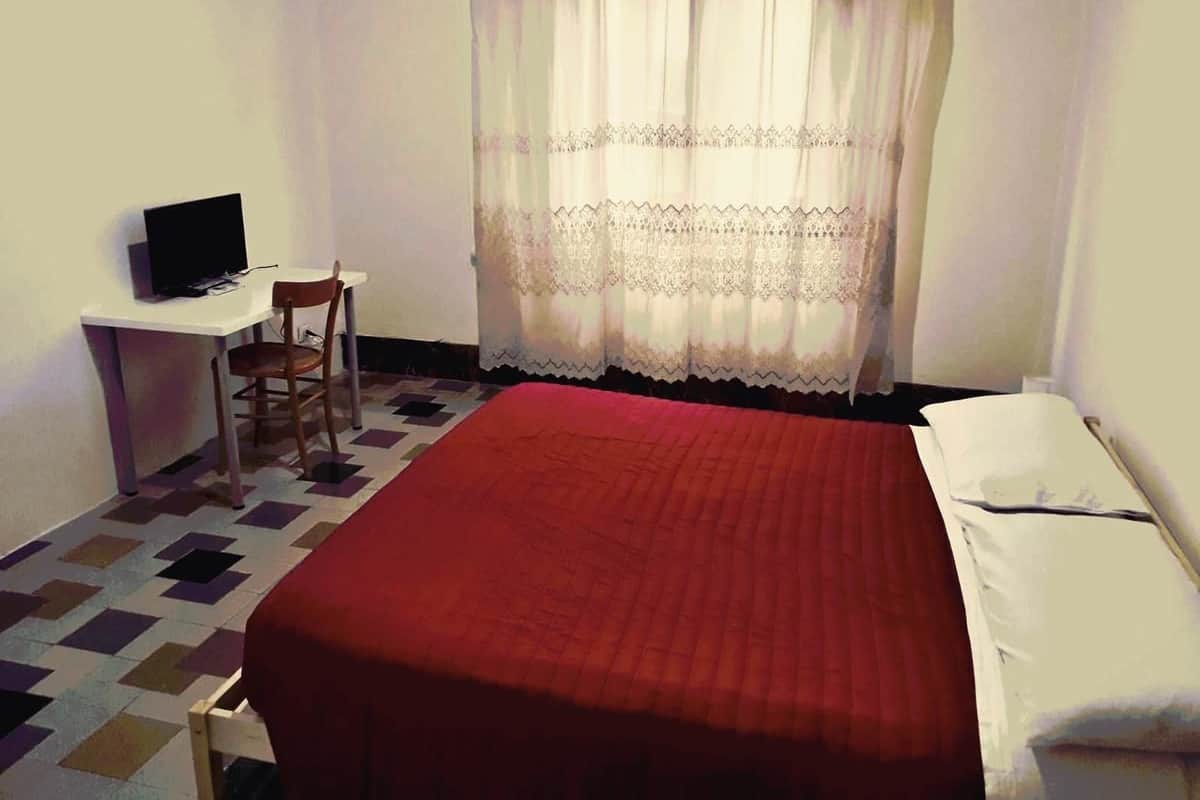 Une pièce comprenant un lit, un bureau et une chaise.