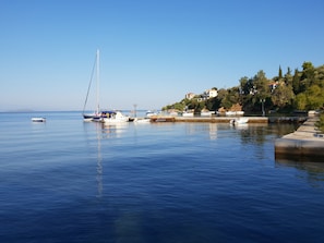 Enjoy a serene waterfront setting with boats moored at the marina, surrounded by lush greenery and residential buildings.
