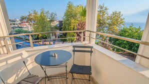 A balcony with a table and chairs, overlooking a residential area and a body of water. - Siete Hotel (Antalya)