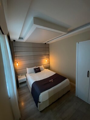 A modern bedroom with a bed, bedside tables, and a wardrobe. - Siete Hotel (Antalya)