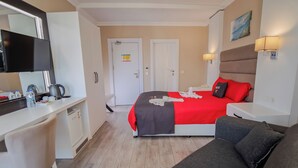 A hotel room with a bed, a desk, a chair, a sofa, a mirror, and a door. - Siete Hotel (Antalya)