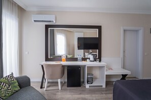 Habitación de hotel con escritorio, silla y un espejo grande.