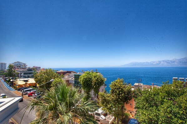 Un paisaje urbano costero con edificios, una carretera y vistas al mar.