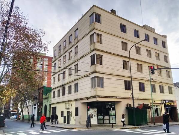 A multi-story building with a ground-level entrance, a visible sign for 'HOTEL', and a pedestrian crossing. - Hotel Lua (Buenos Aires)