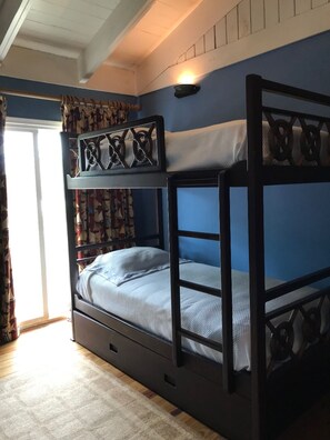 A bunk bed with a headboard and footboard, a window with curtains, and a wall-mounted light fixture. - Cozy apartment with large terrace marine view (La Romana)