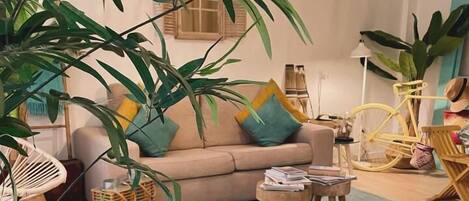A cozy living room with a sofa, a coffee table, and a hanging light fixture.