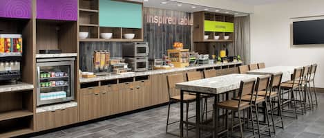 A modern kitchen with a marble countertop, wooden cabinets, and a built-in refrigerator.