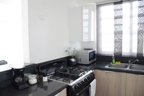 Apartamento conforto, vista para a cidade | Cozinha privada | Geladeira grande, micro-ondas, fogão, cooktop