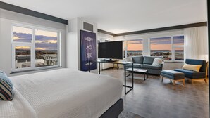 A modern hotel room with a large bed, a flat-screen TV, a sofa, and a desk. - Hotel Indigo Everett - Waterfront Place by IHG (Everett)