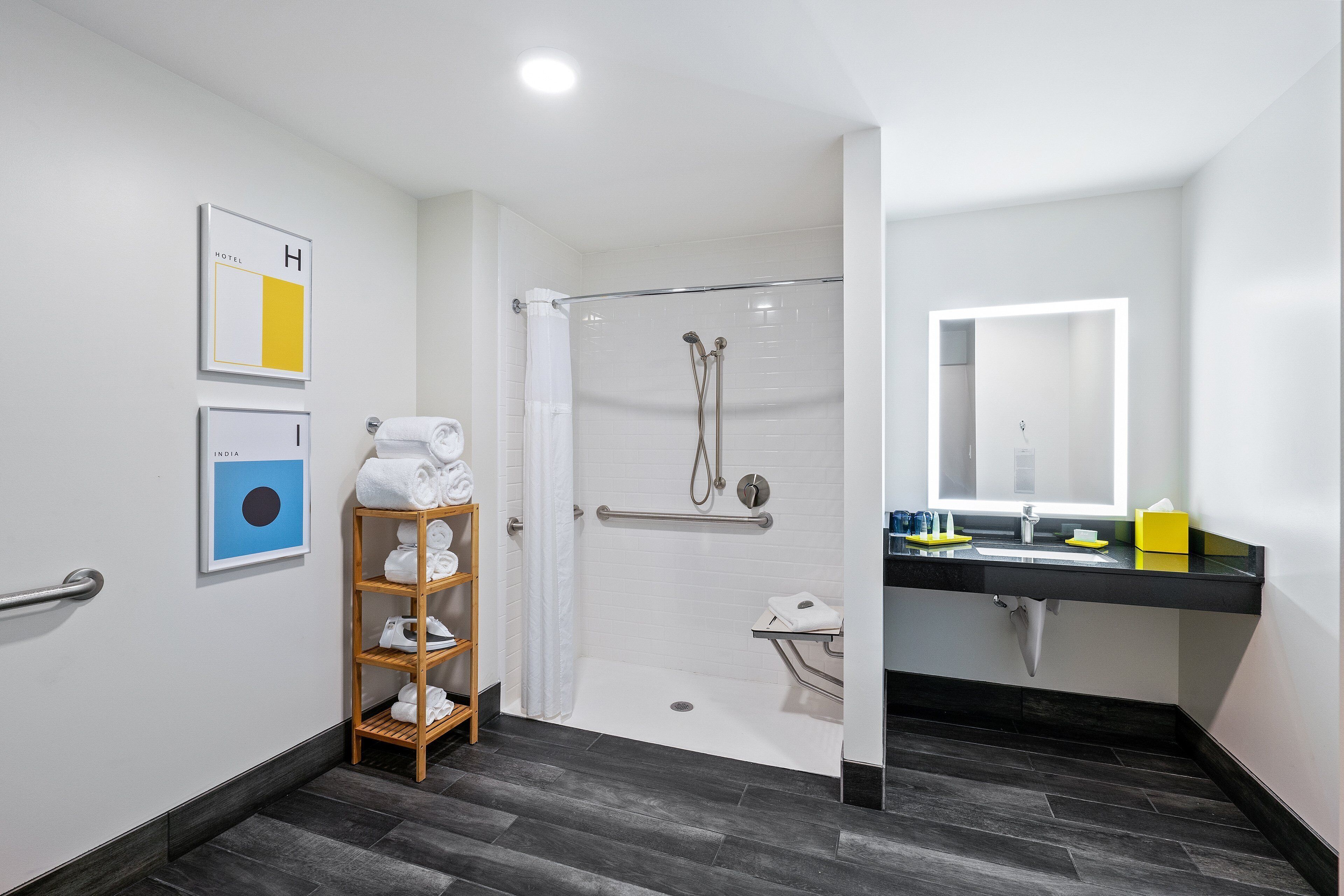A modern bathroom with a glass-enclosed shower, a wooden towel rack, a sink with a mirror, and a toilet.