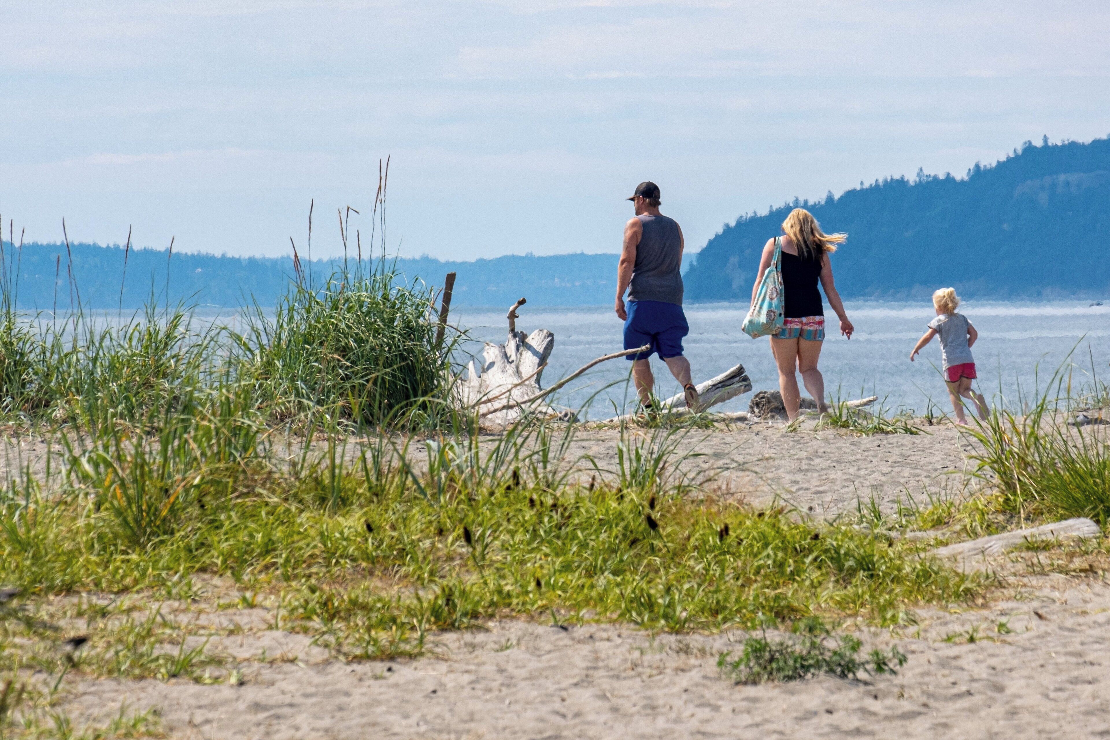 Eine Strandansicht mit Menschen, die am Sand entlanggehen.