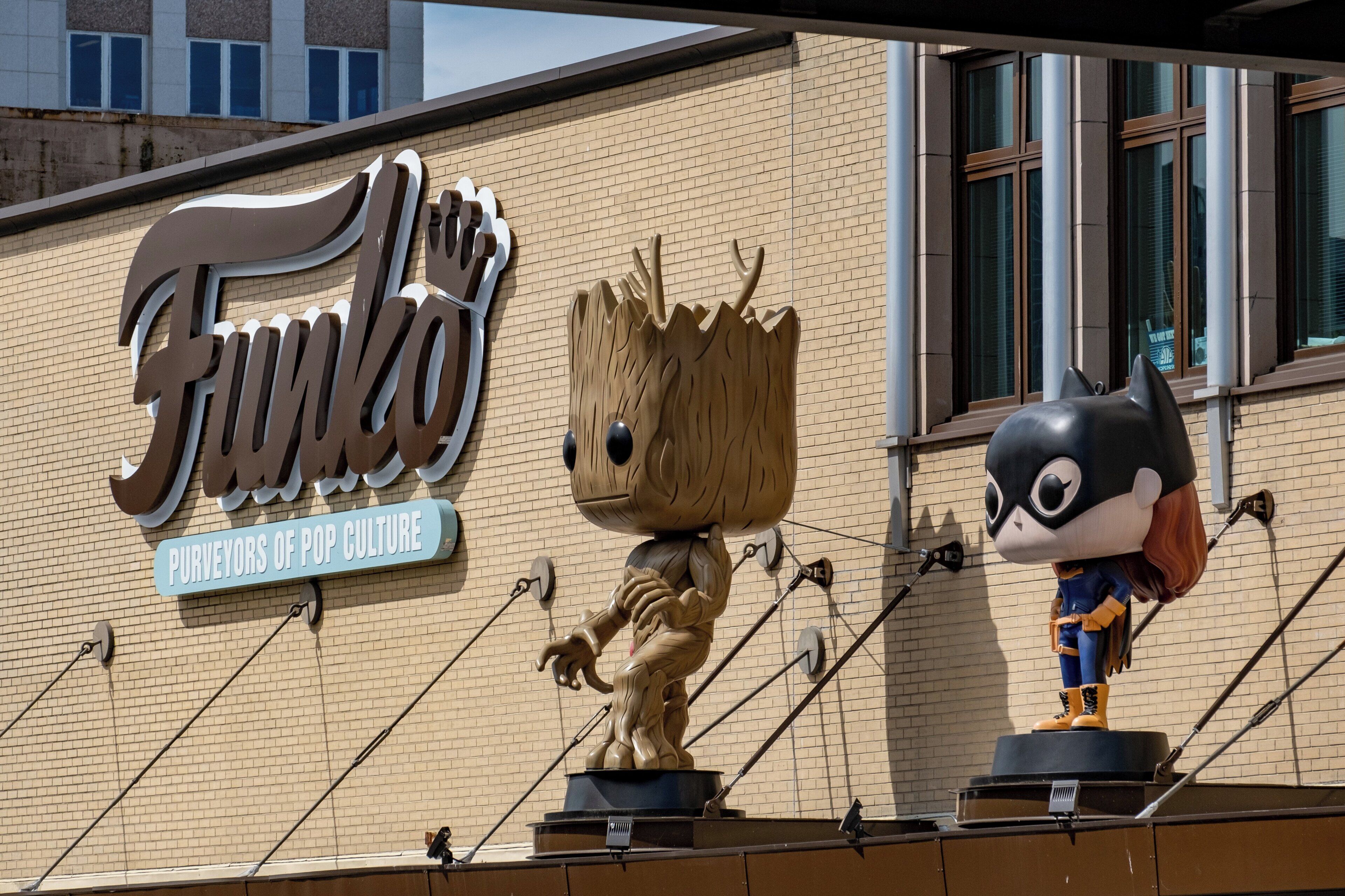 Fachada de edificio con un cartel grande que dice 'Funkos' y dos estatuas de personajes.