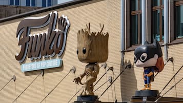 Fachada de edificio con un cartel grande que dice 'Funkos' y dos estatuas de personajes.