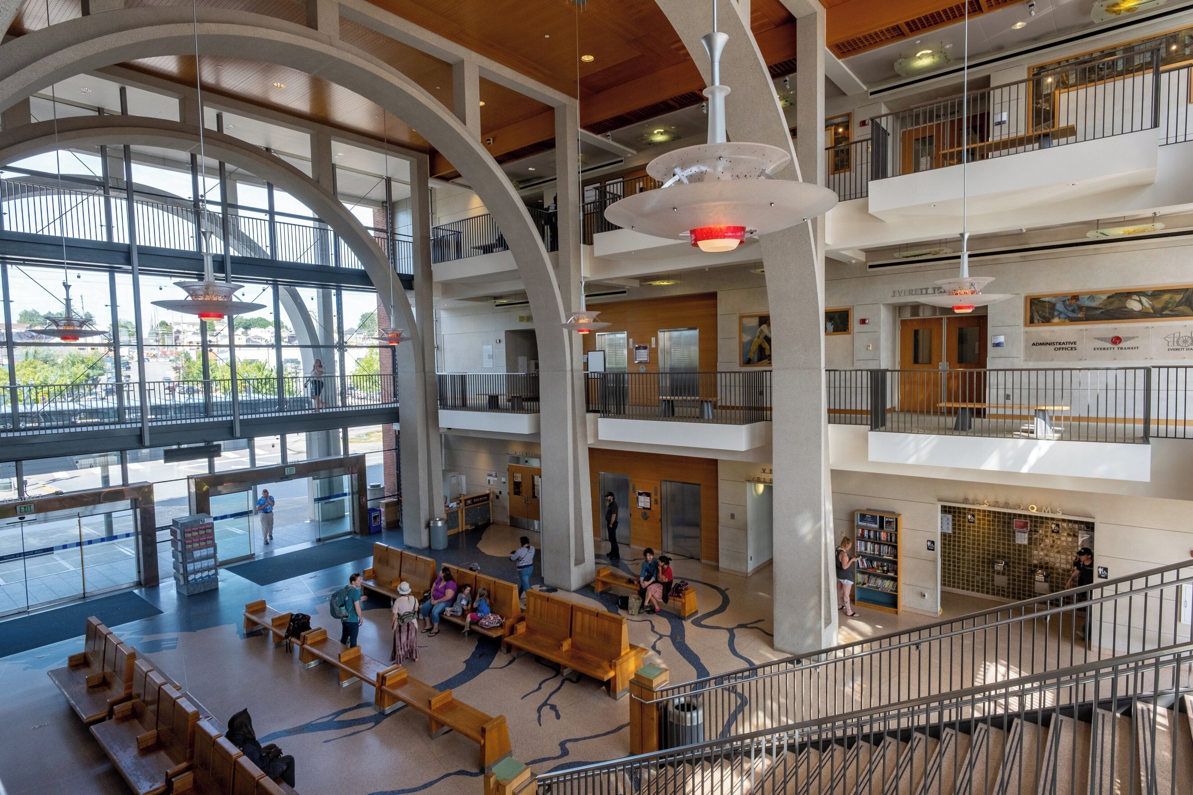 A multi-level atrium with seating areas, elevators, and a view of the outside.