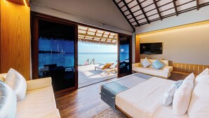 A modern bedroom with a large bed, a sofa, and a balcony with a view of the sea. - Cinnamon Velifushi Maldives (Aarah)