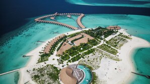 An aerial view of a resort island with overwater bungalows, a central pool, and a beach area. - Cinnamon Velifushi Maldives (Aarah)