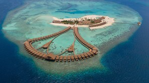 An aerial view of a resort with a crescent-shaped overwater structure, a central building, and a beach area. - Cinnamon Velifushi Maldives (Aarah)