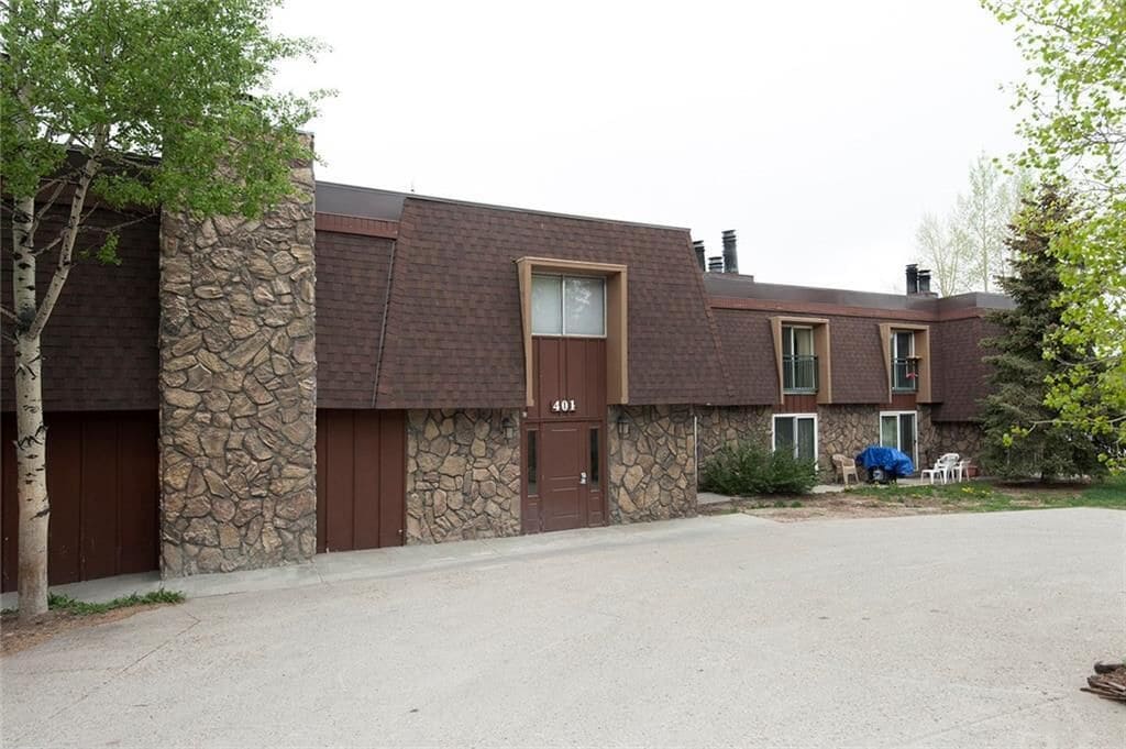 Un edificio de dos pisos con fachada de piedra, una puerta marrón y el número 401.