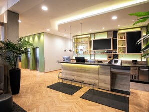 Une cuisine moderne dotée d’un îlot central, d’appareils électroménagers intégrés et d’un coin bar.