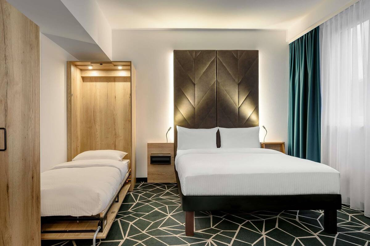 family room, multiple beds (modern with double bed and sofa bed) | 1 bedroom, in-room safe, desk, blackout curtains