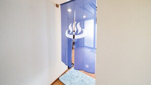 A room with a blue sliding door, a wooden floor, and a light blue rug. - Sea Aiga Kaigetsu (Sumoto)